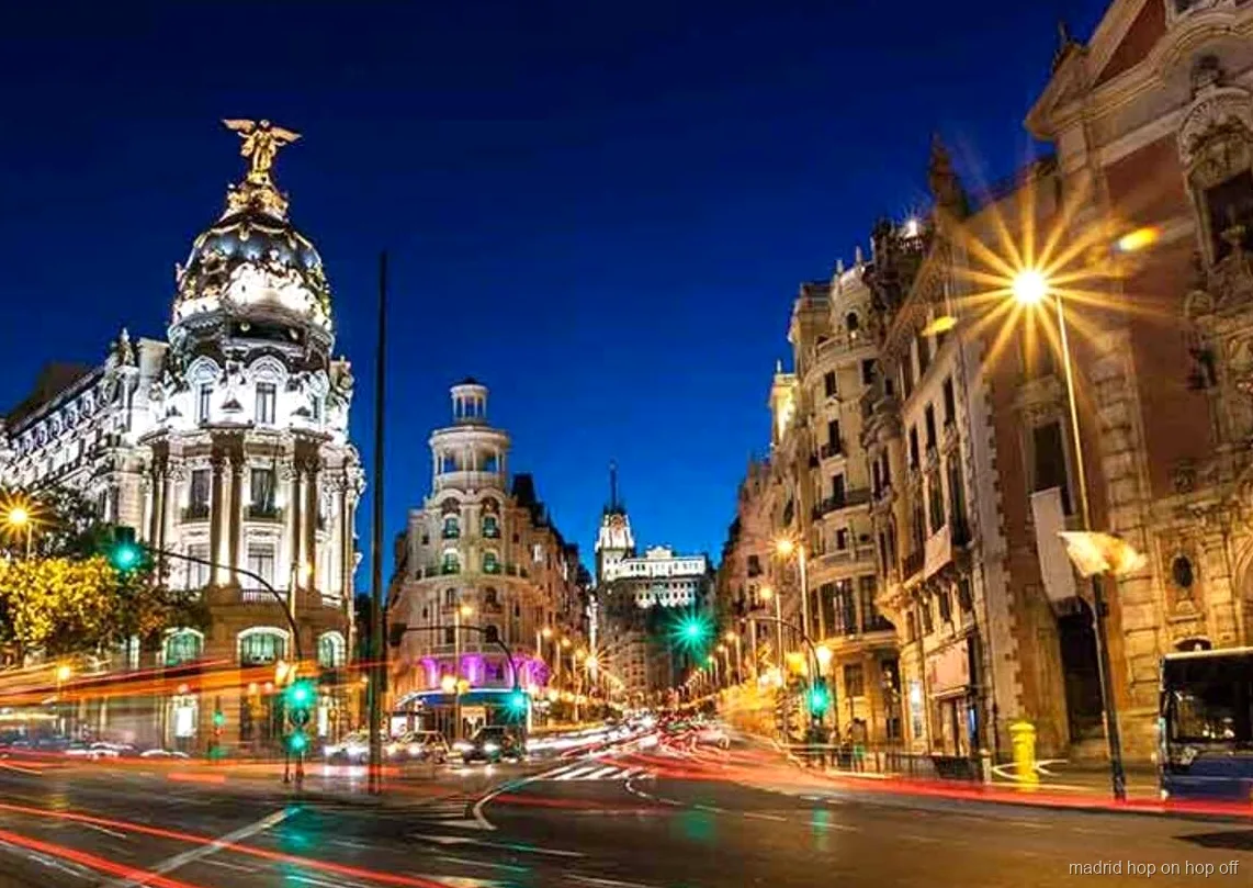 Bus du circuit nocturne hop-on hop-off de Madrid passant devant des monuments illuminés