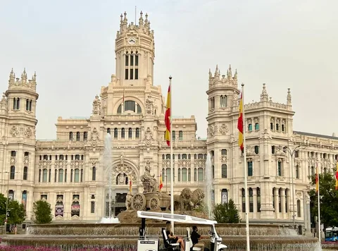Bilingual guide driving an electric tuk tuk through Madrid