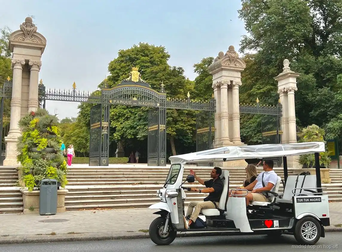 Electric tuk tuk stopped near a Madrid landmark for photos