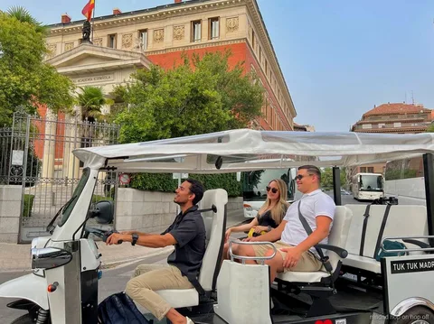 Tour privato in tuk tuk elettrico che passa davanti al Palazzo Reale di Madrid