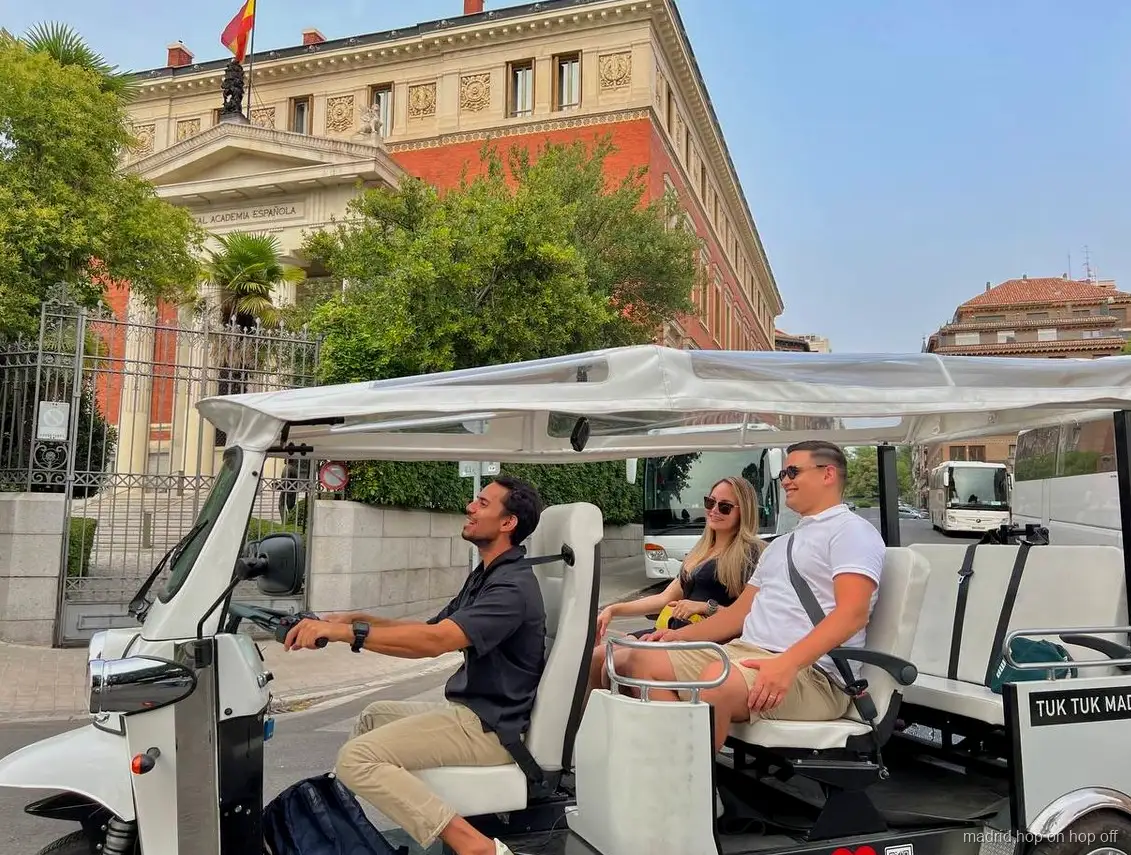 Tuk tuk eléctrico privado pasando frente al Palacio Real de Madrid