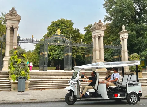 Tuk tuk eléctrico parado cerca de un monumento de Madrid para hacer fotos